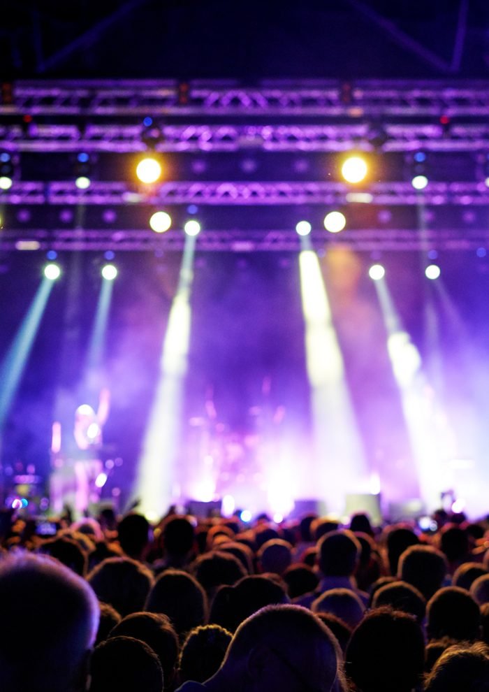 Públic davant d'un escenari de concert il·luminat de nit